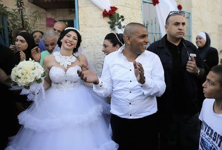 Groom Mahmoud Mansour, 26, (C) and his bride Maral Malka, 23, celebrate with friends and family before their wedding in Mahmoud's family house in Jaffa, south of Tel Aviv August 17, 2014. REUTERS/Ammar Awad