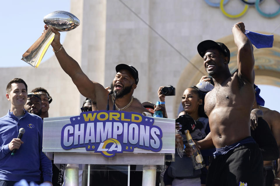 Los Angeles Rams defensive lineman Aaron Donald, center, holds up the Vince Lombardi Super Bowl trophy as he celebrates with linebacker Ogbonnia Okoronkwo, right, during the team's victory celebration in Los Angeles, Wednesday, Feb. 16, 2022. The Rams beat the Cincinnati Bengals Sunday in the NFL Super Bowl 56 football game. (AP Photo/Marcio Jose Sanchez)