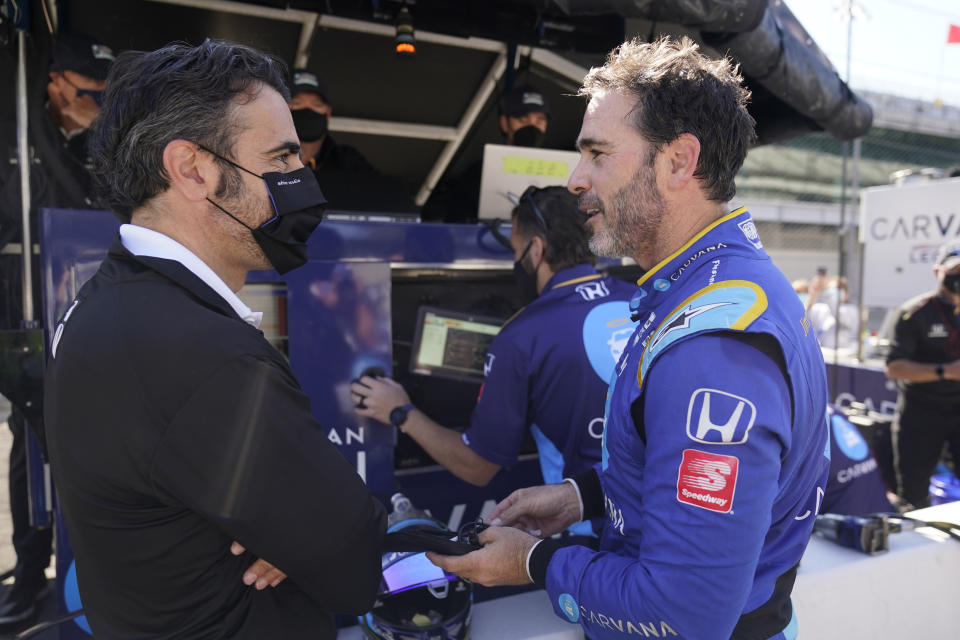 Jimmie Johnson talks with Dario Franchitti, left, following a practice session for the IndyCar auto race at Indianapolis Motor Speedway, Friday, May 14, 2021, in Indianapolis. (AP Photo/Darron Cummings)