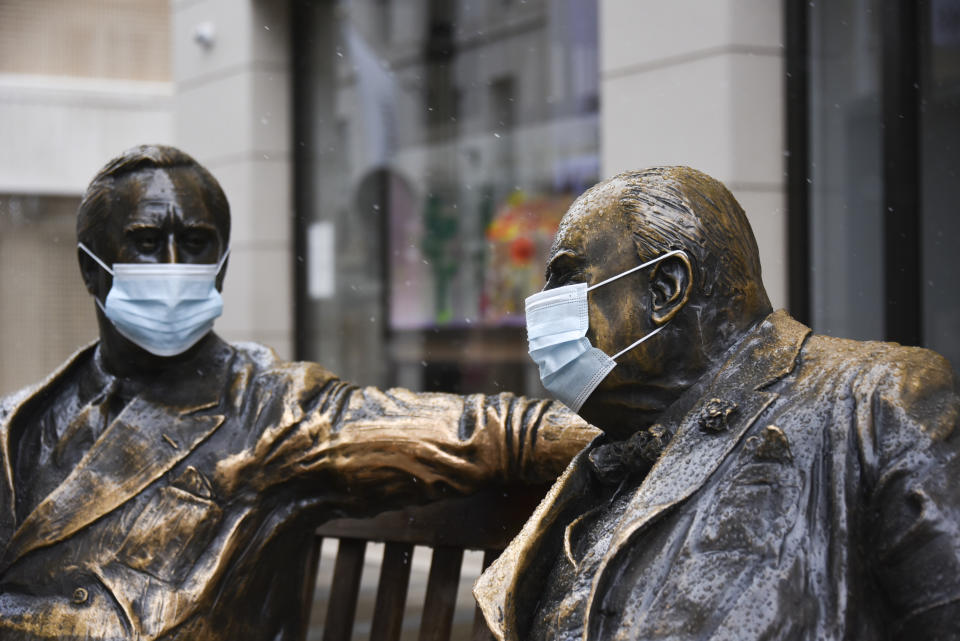 Face coverings on the statues of former US President Franklyn D. Roosevelt, left, and former British Prime Minister Winston Churchill in Mayfair, London, Sunday, Feb. 7, 2021, as the third national lockdown, due to the COVID-19 outbreak, continues. (AP Photo/Alberto Pezzali)