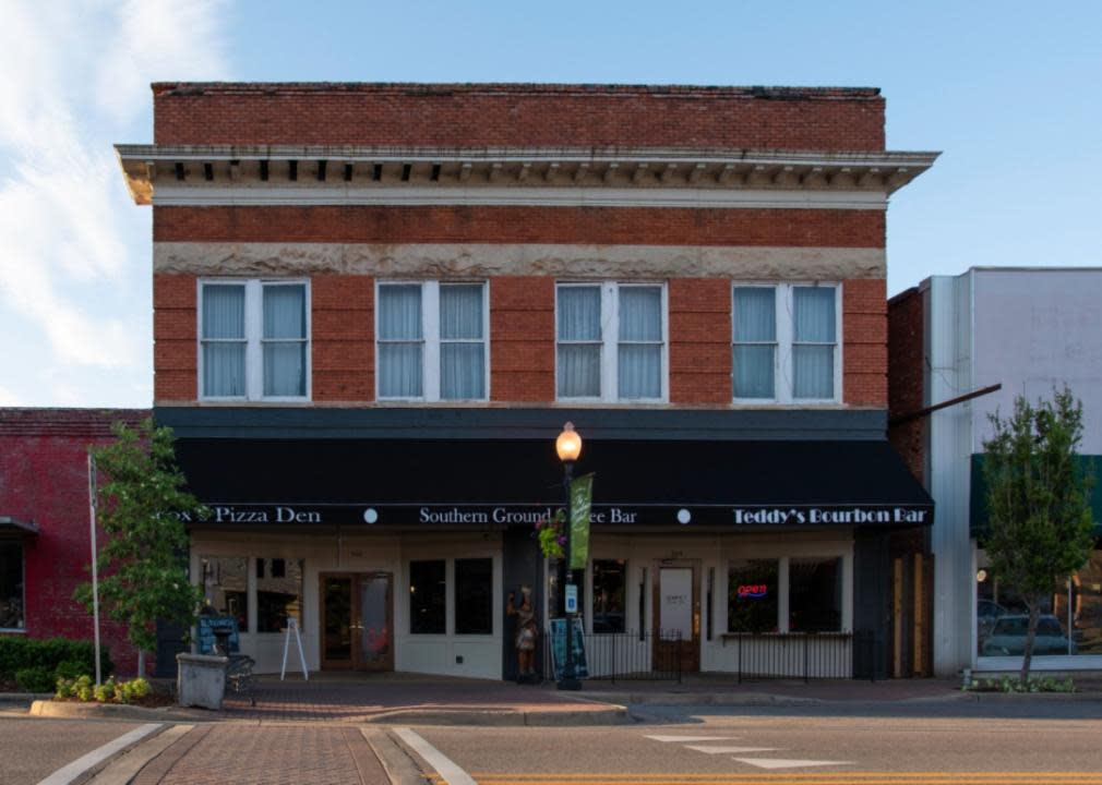 A historic brick building with pizza and bars on the bottom floor.