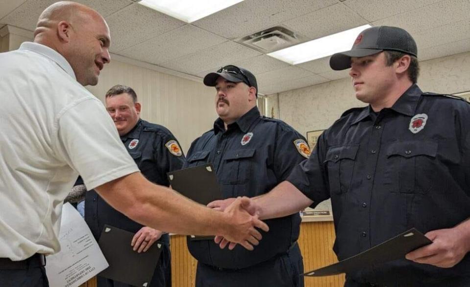 Uhrichsville Fire Chief Justin Edwards (Left) congratulations firefighters Sean Luce, Taylor Fach and Corey Paisley, who were honored at a recent city council meeting.