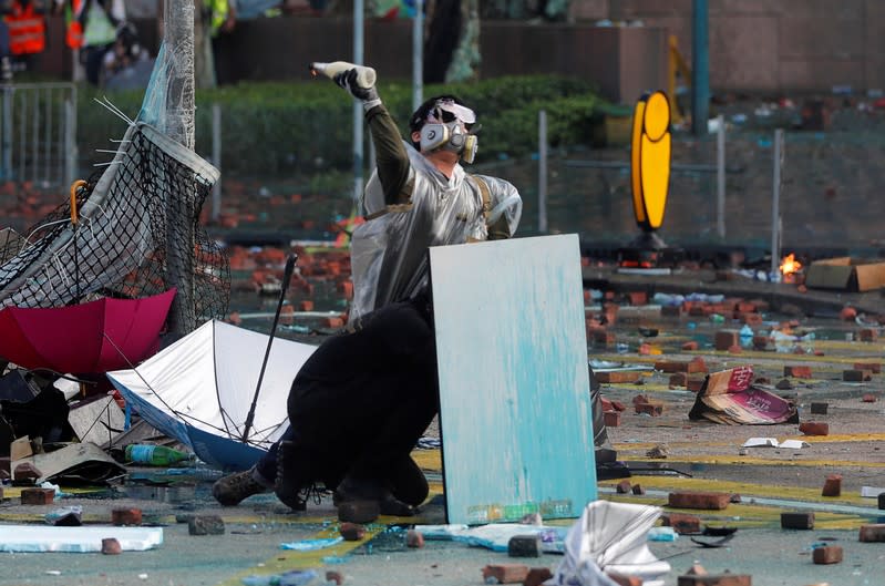 Protesters take cover during clashes with police outside Hong Kong Polytechnic University
