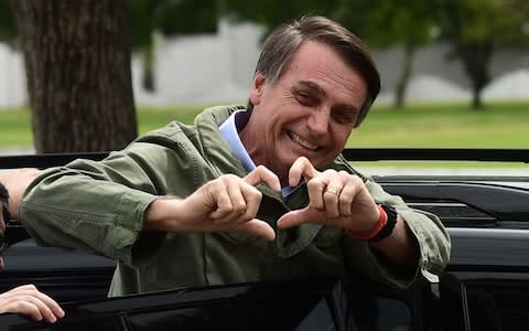 Jair Bolsonaro, far-right lawmaker and presidential candidate for the Social Liberal Party (PSL), gestures to supporters during the second round of the presidential elections, in Rio de Janeiro - Credit: AFP