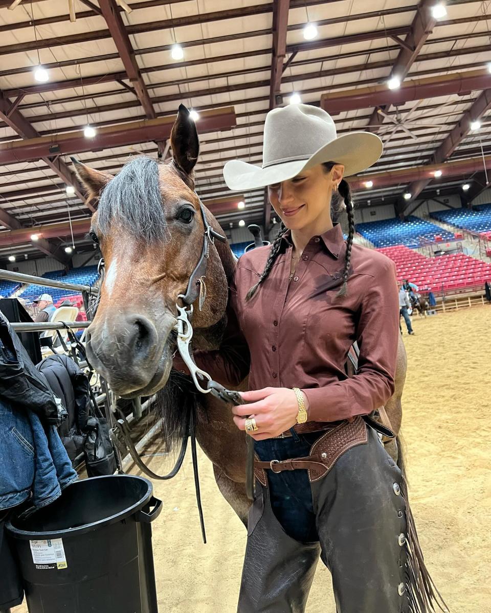 Bella Hadid wearing a brown button down with pants and a western hat