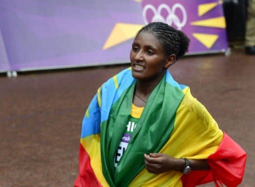 La atleta etíope Tiki Gelana, con la bandera de su país tras proclamarse campeona olímpica en la maratón, una de las pruebas reinas de los Juegos de Londres, este domingo. (AFP | Daniel García)