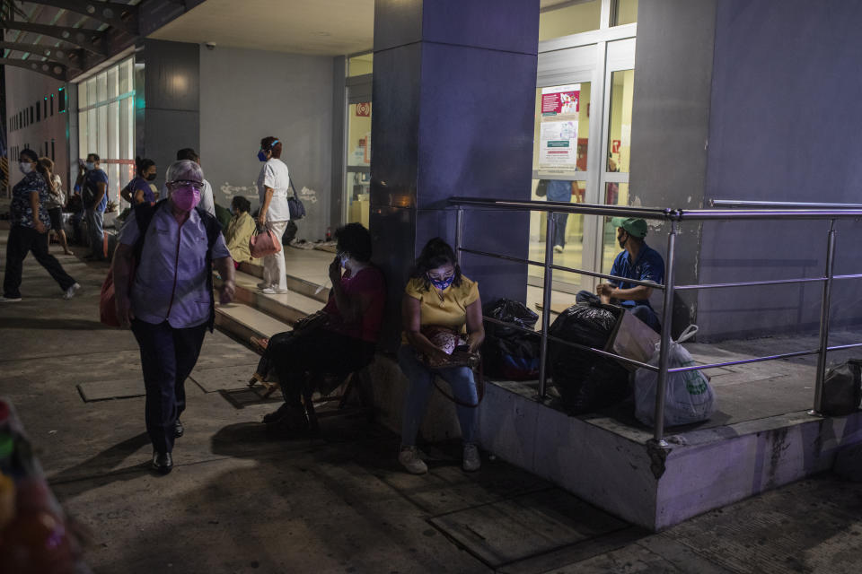 People check their mobile phones outside Veracruz General Hospital after a strong earthquake, in Veracruz, Mexico, Tuesday, Sept. 7, 2021. The quake struck southern Mexico near the resort of Acapulco, causing buildings to rock and sway in Mexico City nearly 200 miles away. (AP Photo/Felix Marquez)
