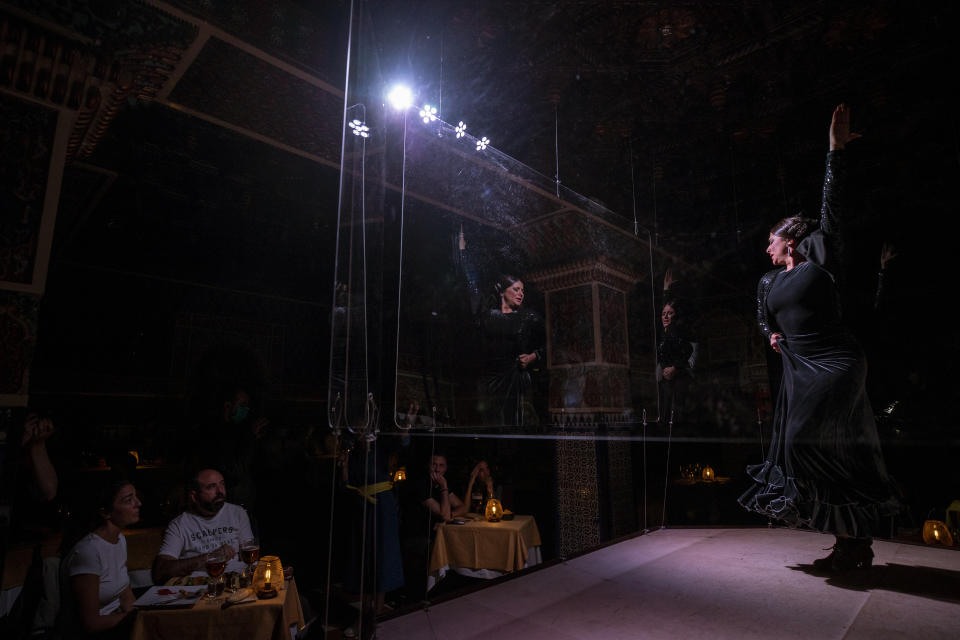 Flamenco dancer Antonia Estepa performs behind screens during a flamenco show at the Torres Bermejas "tablao," or live flamenco venue, in Madrid, Spain, Friday, Sept. 25, 2020. The passion and drama of live flamenco shows are back on stage in Madrid. But now the performers are behind Perspex screens and keeping their distance from the audience. The Torres Bermejas “tablao,” or live flamenco venue, has reopened its doors to customers after seven months closed due to the COVID-19 pandemic. (AP Photo/Manu Fernandez)