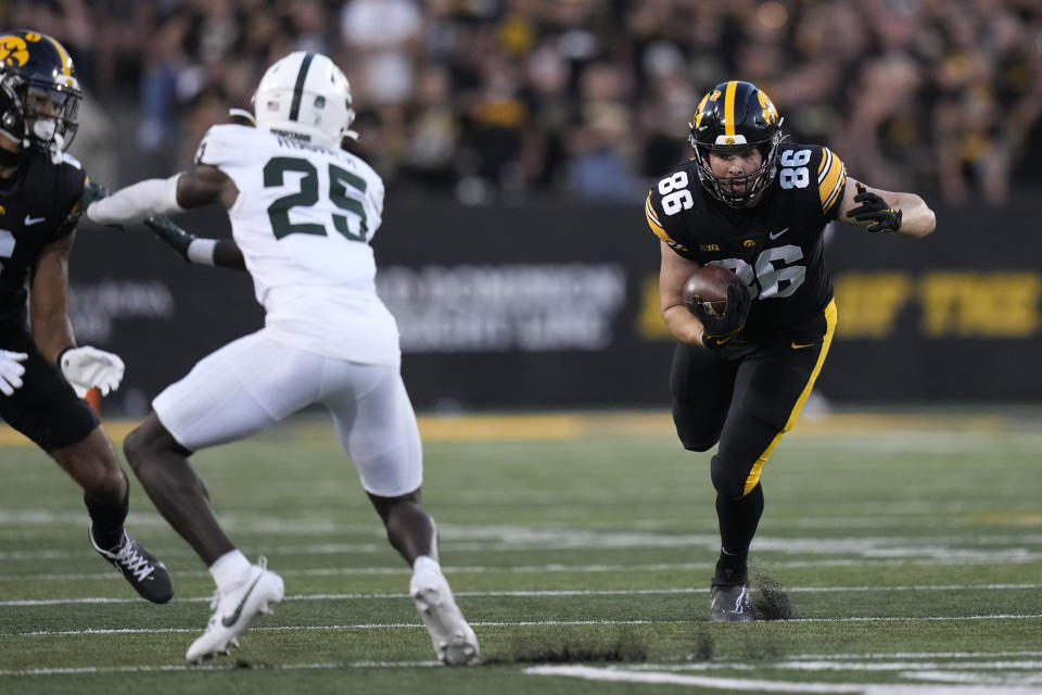 Iowa tight end Steven Stilianos (86) runs from Michigan State linebacker Sam Edwards (35) after catching a pass during the first half of an NCAA college football game, Saturday, Sept. 30, 2023, in Iowa City, Iowa. (AP Photo/Charlie Neibergall)