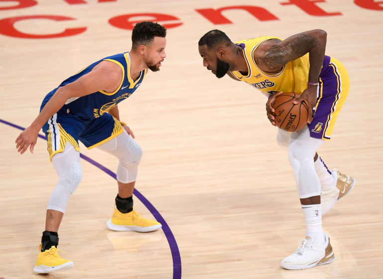 LOS ANGELES, CALIFORNIA - JANUARY 18: LeBron James #23 of the Los Angeles Lakers is guarded by Stephen Curry.