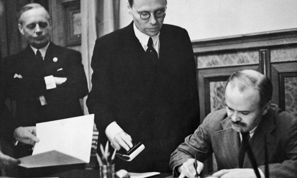 Soviet foreign minister Vyacheslav Mikhailovich Molotov signs the Soviet-German Non-Aggression Pact in Moscow, 23 August 1939. On the left is German foreign minister Joachim von Ribbentrop