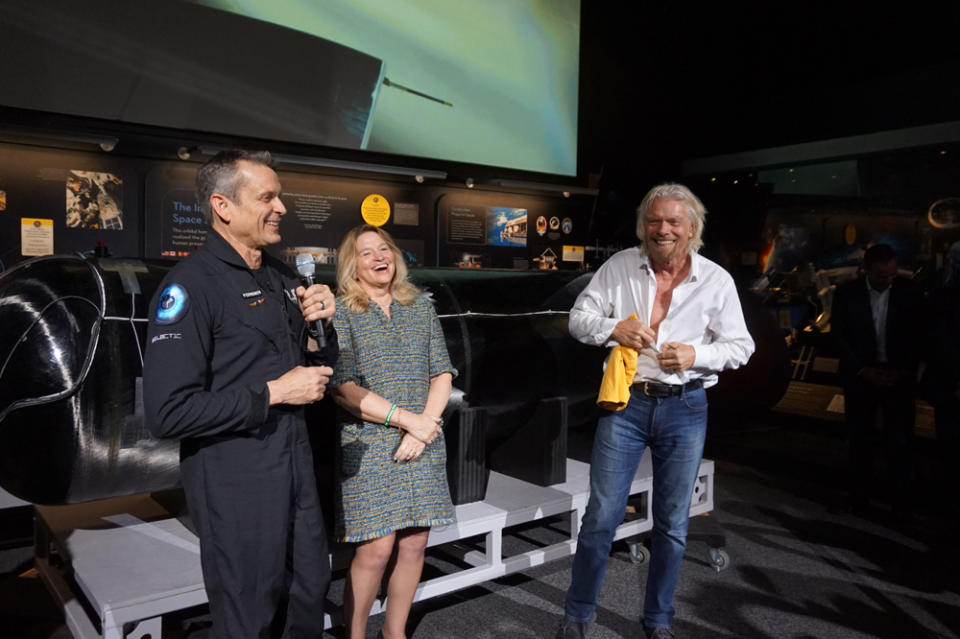 Richard Branson prepares to don a "Future Astronaut Training Program" T-shirt, given to him by Astronaut Mark Stucky (who no longer qualifies as a "future astronaut"), alongside Ellen Stofan, the director of the National Air and Space Museum. <cite>Chelsea Gohd/Space.com</cite>