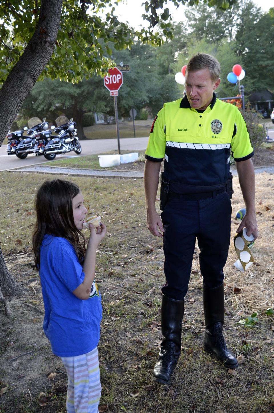 Lt. Micah Taylor with the Madison Police Department talks with Lucy Kaye Stokley, 7, of Madison during Night Out festivities held at the Cobblestone subdivision in Madison on Tuesday, Oct. 3.