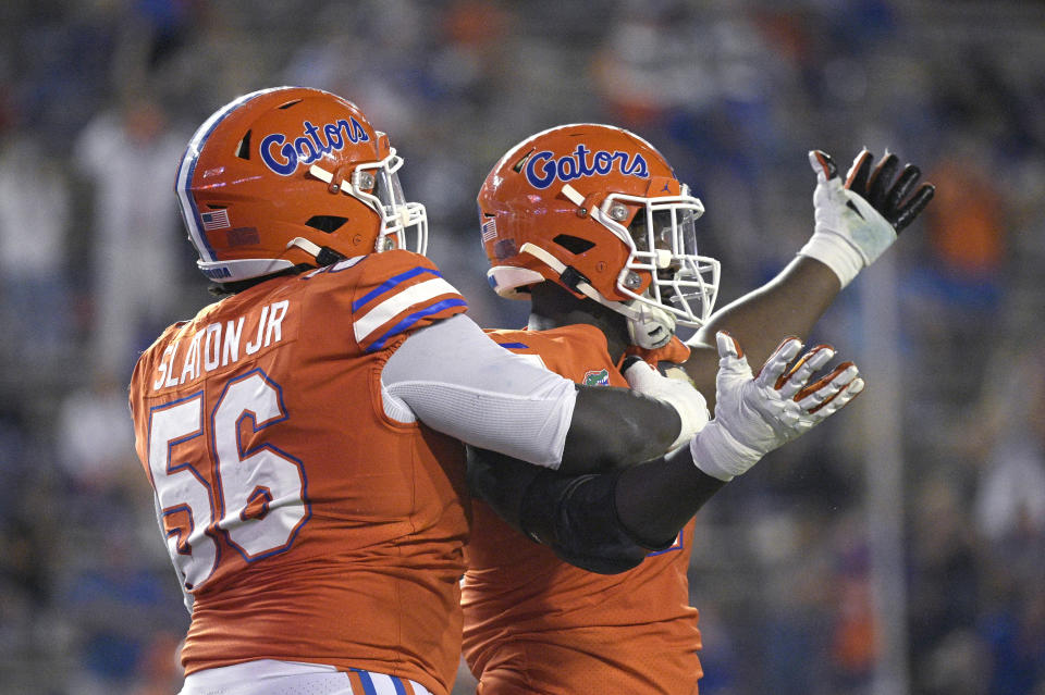 Florida defensive lineman Tedarrell Slaton (56) congratulates defensive lineman Zachary Carter after Carter sacked Arkansas quarterback Feleipe Franks during the first half of an NCAA college football game Saturday, Nov. 14, 2020, in Gainesville, Fla. (AP Photo/Phelan M. Ebenhack)