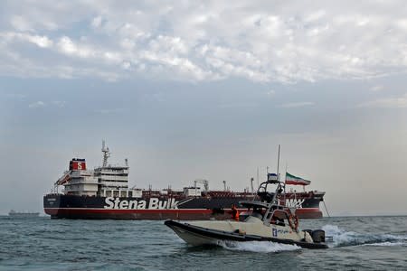 FILE PHOTO: A boat of Iranian Revolutionary Guard sails next to Stena Impero, a British-flagged vessel owned by Stena Bulk, at Bandar Abbas port