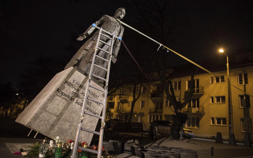 Activists in Poland pull down a statue of a prominent deceased priest, Father Henryk Jankowski, who allegedly abused minors sexually, in Gdansk, Poland, on Thursday Feb. 21, 2019. The activists said it was an act of protest against the Polish Catholic Church for failing in resolving the problem of clergy sex abuse. The protest comes as Pope Francis has gathered church leaders from around the world at the Vatican to grapple with the church's sex abuse crisis. (AP Photo/Bartek Sabela/Gazeta Wyborcza)