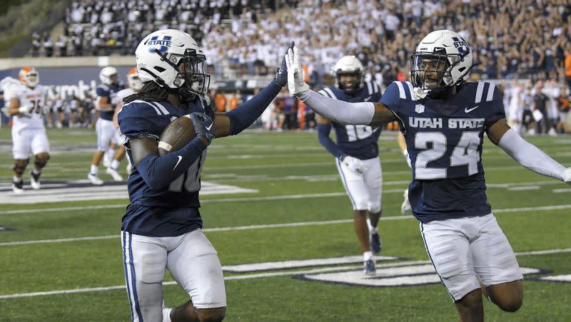 Utah State cornerback Jaiden Francois (10) and cornerback Gabriel Bryan (24) celebrate as Francois returns an interception for a touchdown during the second half of an NCAA college football game against Idaho State on Saturday, Sept. 9, 2023, in Logan, Utah. 