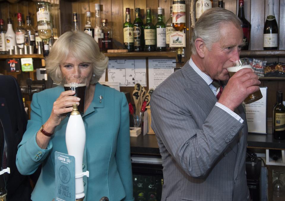 Camilla Parker-Bowles and Prince Charles drink at a Welsh pub in 2015 (Rex)