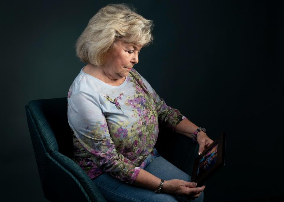 Carole Cleveland looks down at a photograph of her son Shane Breedlove whose 2015 murder remains unsolved in Evansville, Ind., Thursday, July 13, 2023.