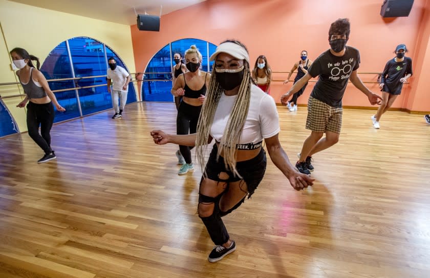 Dance instructor Ebonee Arielle leads masked students in a pandemic hip hop class at 3rd Street Dance Studio in Los Angeles.