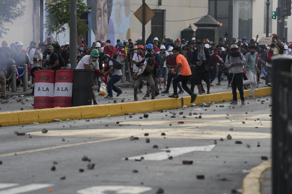 Anti-government protesters clash with police in downtown Lima, Peru, Tuesday, Jan. 24, 2023. Protesters are seeking the resignation of President Dina Boluarte, the release from prison of ousted President Pedro Castillo, immediate elections and justice for demonstrators killed in clashes with police. (AP Photo/Martin Mejia)