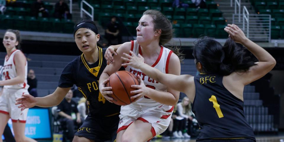 Kent City's Lexie Bowers (23) fights through the defense of  Madison Heights Bishop Foley's Teresa Weis (left) and 
 Abby Pasinos during an MHSAA Division 3 girls semifinal March 17, 2022, at the Breslin Center in East Lansing. Kent City won the game, 47-30, to move on to the Division 3 final on Saturday and will play Ypsilanti Arbor Prep.