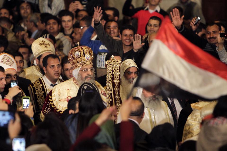 Egyptian Coptic Christians wave to Pope Tawadros II as they attend the Coptic Christmas Eve Mass in Cairo