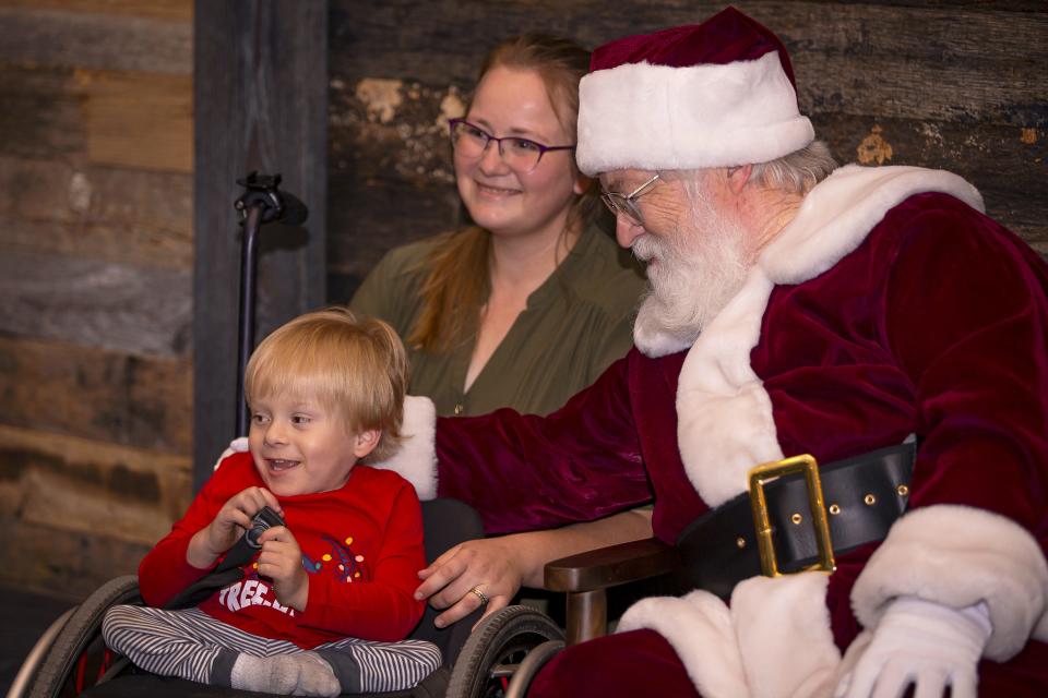 Oliver Garza-Pena and Demi Porter pose for a photo with Santa Claus during a Sensitive Santa event at Christ's Church of the Valley in Peoria on Dec. 2, 2021.