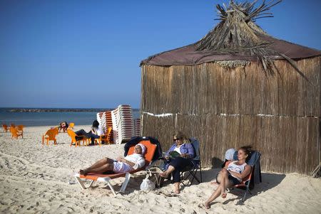 Jewish tourists from France, who say they plan to move to Israel, sit on the beach in Netanya, a city of 180,000 on the Mediterranean north of Tel Aviv, that has become the semi-official capital of the French community in Israel January 20, 2015. REUTERS/Amir Cohen