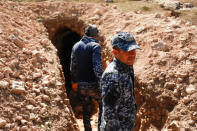 Federal police members are seen at the entrance of a tunnel used by Islamic State militants on the outskirts Albu Saif, which was recently retaken by Iraqi military forces, south of Mosul, Iraq February 22, 2017. REUTERS/Zohra Bensemra