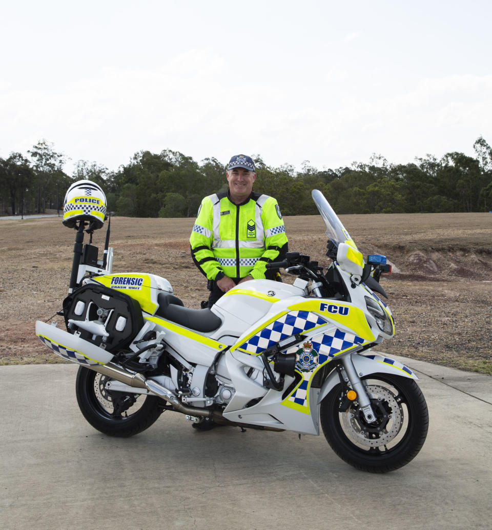 Sergeant Carl Cutler pictured with his Queensland Police motorbike