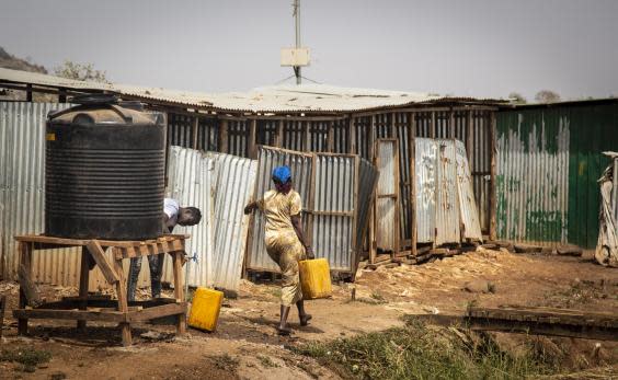 A South Sudanese woman collects water for her family at a tank in a UN-protected displacement camp in Juba (Bel Trew)