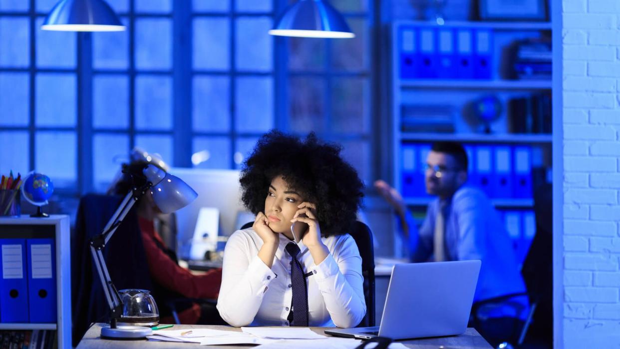 African woman working late in modern workplace.