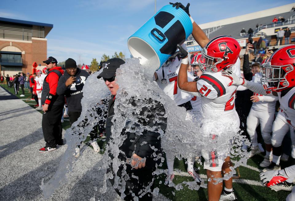 Carl Albert's Xavier Robinson (21) and Trey Washington (7) douse coach Mike Dunn with ice water after Carl Albert's win in the Class 5A state football championship game between the Carl Albert Titans and the McAlester Buffaloes at Chad Richison Stadium in Edmond Saturday, Dec. 3, 2022. Carl Albert won 49-7.