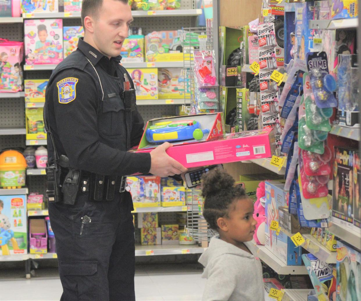 Cheboygan City Police Officer Bret Auger shops with a child during the Shop with a Hero event held at the Cheboygan Walmart on Wednesday.