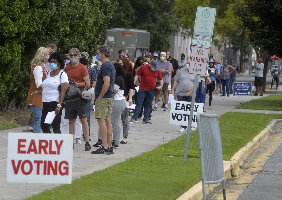 A line of voters waits at a Savannah polling location during the 2020 election. Georgia voters can start going to the polls for the May 24 nonpartisan and primary elections this week.