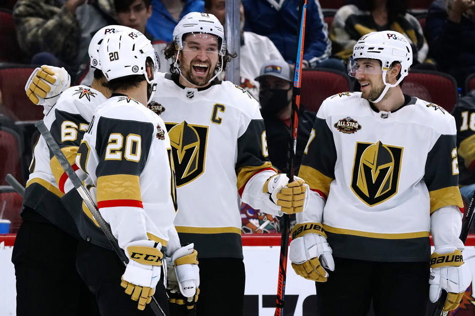 Vegas Golden Knights left wing Max Pacioretty, left, celebrates his goal against the Arizona Coyotes with center Chandler Stephenson (20), right wing Mark Stone, second from right, and defenseman Shea Theodore, right, during the second period of an NHL hockey game Friday, Dec. 3, 2021, in Glendale, Ariz. (AP Photo/Ross D. Franklin)