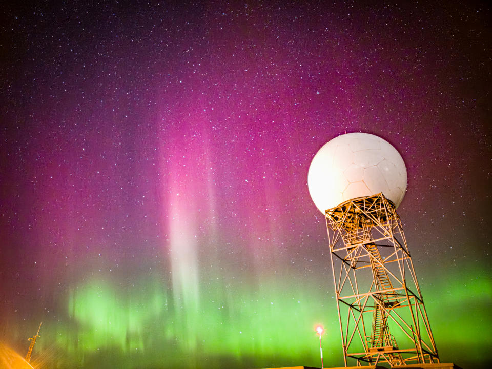 Vibrant pink and purple aurora dance over green auroras.