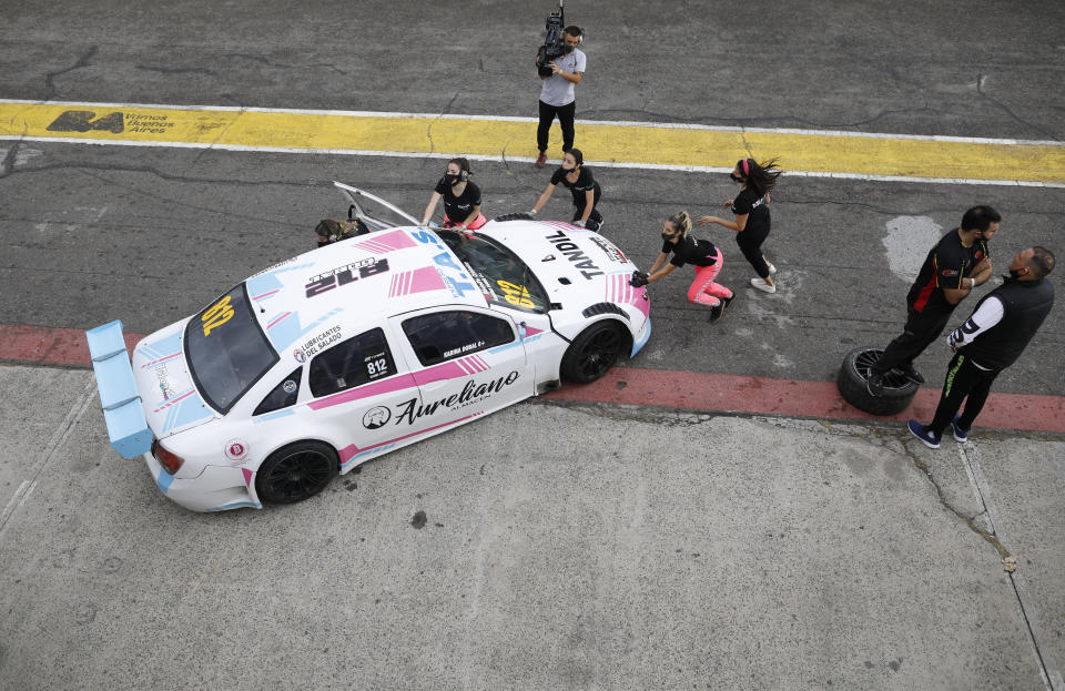 Vitarti Girl’s Team mechanics, from left, Paula Salazar, Agustina Carreira, team Director Tamara Vital, and mechanic Victoria Pascual push their racing car with driver Karina Dobal at the wheel into pits after the team's first race at the Oscar y Juan Galvez track in Buenos Aires, Argentina, Sunday, April 4, 2021. The Vitarti Girl's Team is comprised of a director, engineers, mechanics and drivers, all women, and started competing in April in the Top Race Junior series. (AP Photo/Natacha Pisarenko)