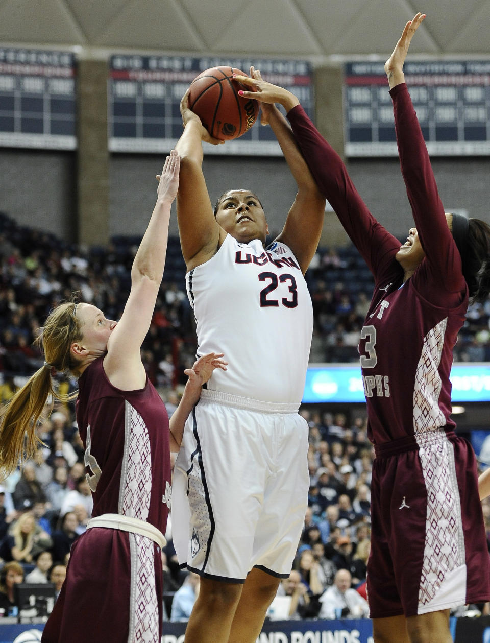 Connecticut's Kaleena Mosqueda-Lewis goes up for a basket as Saint Joseph's Erin Shields, left, and Ashley Robinson, right, defend during the first half of a second-round game of the NCAA women's college basketball tournament, Tuesday, March 25, 2014, in Storrs, Conn. (AP Photo/Jessica Hill)