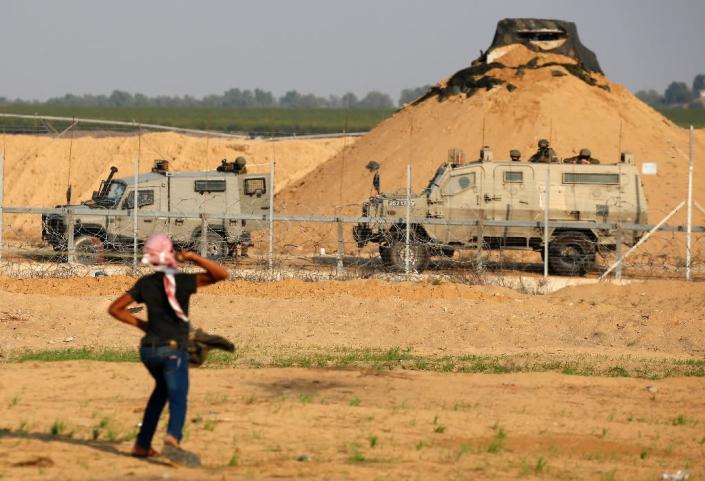 A Palestinian protester throws a rock at Israeli soldiers during a demonstration along the barrier between Israel and the Gaza Strip on November 9, 2018 (AFP Photo/Said KHATIB)