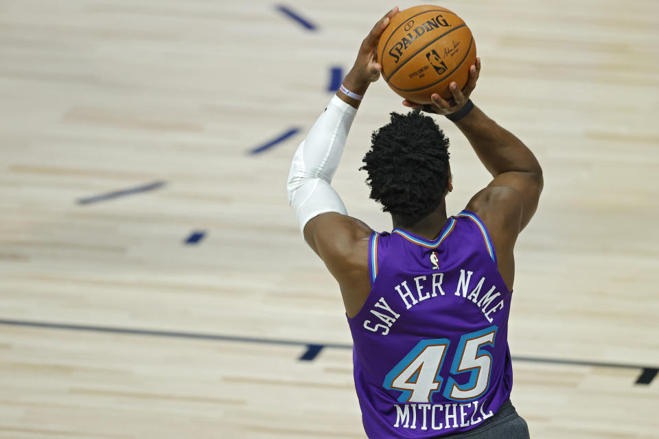 Donovan Mitchell shoots a basketball wearing his "Say Her Name" jersey.