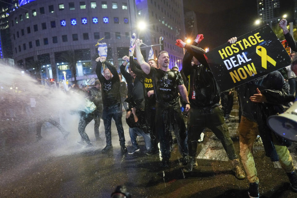 Police use water cannons to disperse demonstrators during a protest against Israeli Prime Minister Benjamin Netanyahu's government, and calling for the release of hostages held in the Gaza Strip by the Hamas militant group, in Tel Aviv, Israel, Saturday, Feb. 24, 2024. (AP Photo/Ohad Zwigenberg)