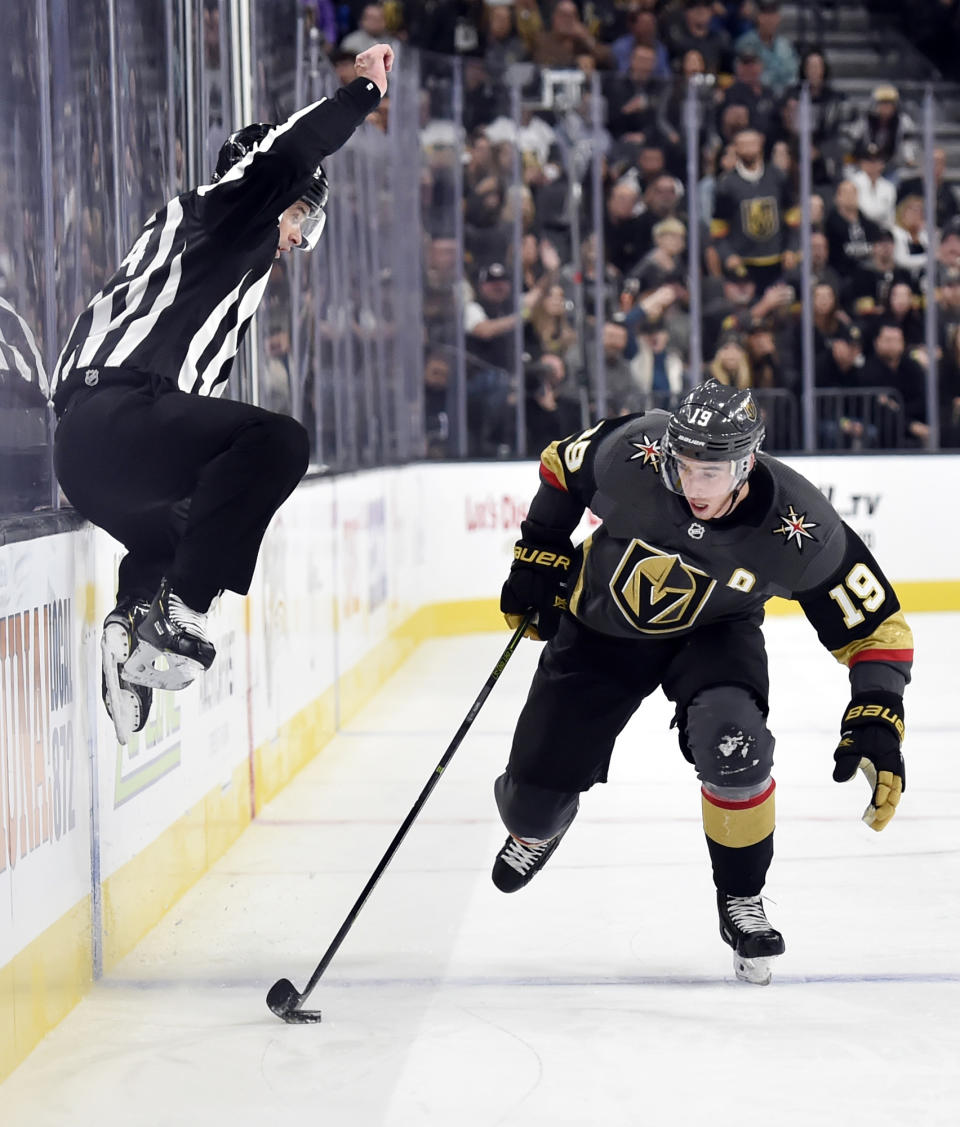 Linesman Brandon Gawryletz jumps to avoid contact against Vegas Golden Knights right wing Reilly Smith (19) as he skates with the puck against the Buffalo Sabres during the second period of an NHL hockey game, Tuesday, Oct. 16, 2018, in Las Vegas. (AP Photo/David Becker)