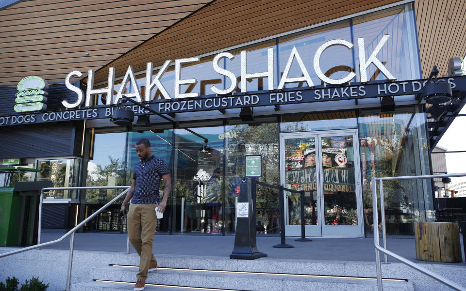 FILE - In this April 15, 2015, file photo, a man walks out of a Shake Shack in front of the New York-New York hotel and casino in Las Vegas. Shake Shack reports financial results Wednesday, Aug. 10, 2016. (AP Photo/John Locher, File)