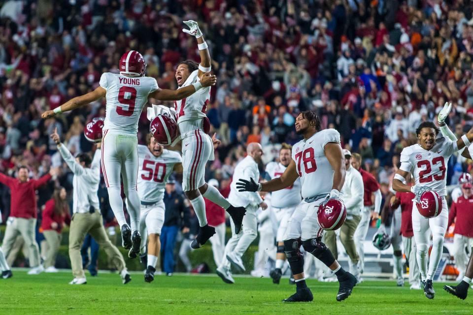 Alabama quarterback Bryce Young (9) and defensive back Devonta Smith (27) celebrate after a 24-22 four-overtime win in an NCAA college football game against Auburn, Saturday, Nov. 27, 2021, in Auburn, Ala. (AP Photo/Vasha Hunt)