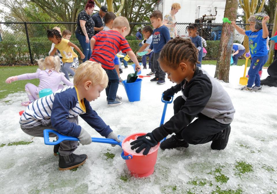 As other children play, Luke Bailey (from left) and Aven Charlton, both 3, work together to fill a bucket with crushed ice during a 2020 snow day at the Bright Horizons at the Avenues child care center.