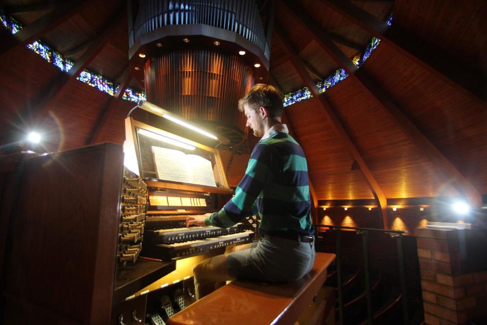 Organist Christopher Keady plays the circular pipe organ at the Agnes Flanagan Chapel Tuesday, June 12, 2012, on the campus of Lewis & Clark College, in Portland, Ore. The Agnes Flanagan Chapel is a 16-sided architectural marvel that seats 650 under stained glass windows depicting the book of Genesis. In the early 1970s, it was also a big, conical quandary. Chapels aren’t really chapels unless they have an organ, and the newly-minted structure at Portland’s Lewis & Clark College was in need. (AP Photo/Rick Bowmer)