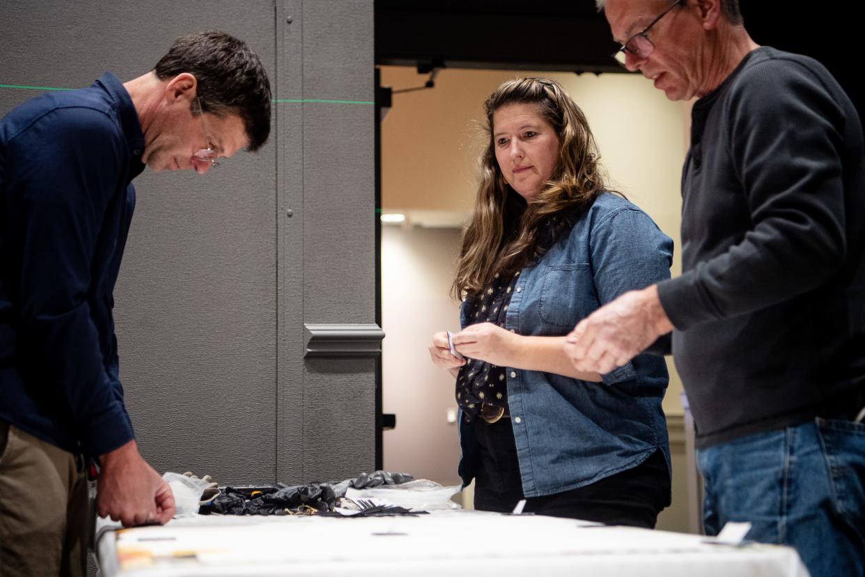 Kaley Ellis, center, project manager of exhibitions with Chihuly Studio, works with Chris Pfeifle, left, and Paul Arnhold, right, to install a mural in the Chihuly exhibit at Amherst on the Biltmore Estate, March 20, 2024.