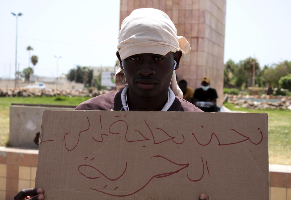 A migrant holds a placard reading "We need freedom" during a gathering in Sfax, Tunisia's eastern coast, Friday, July 7, 2023. Tensions spiked dangerously in a Tunisian port city this week after three migrants were detained in the death of a local man, and there were reports of retaliation against Black foreigners and accounts of mass expulsions and alleged assaults by security forces. (AP Photo)
